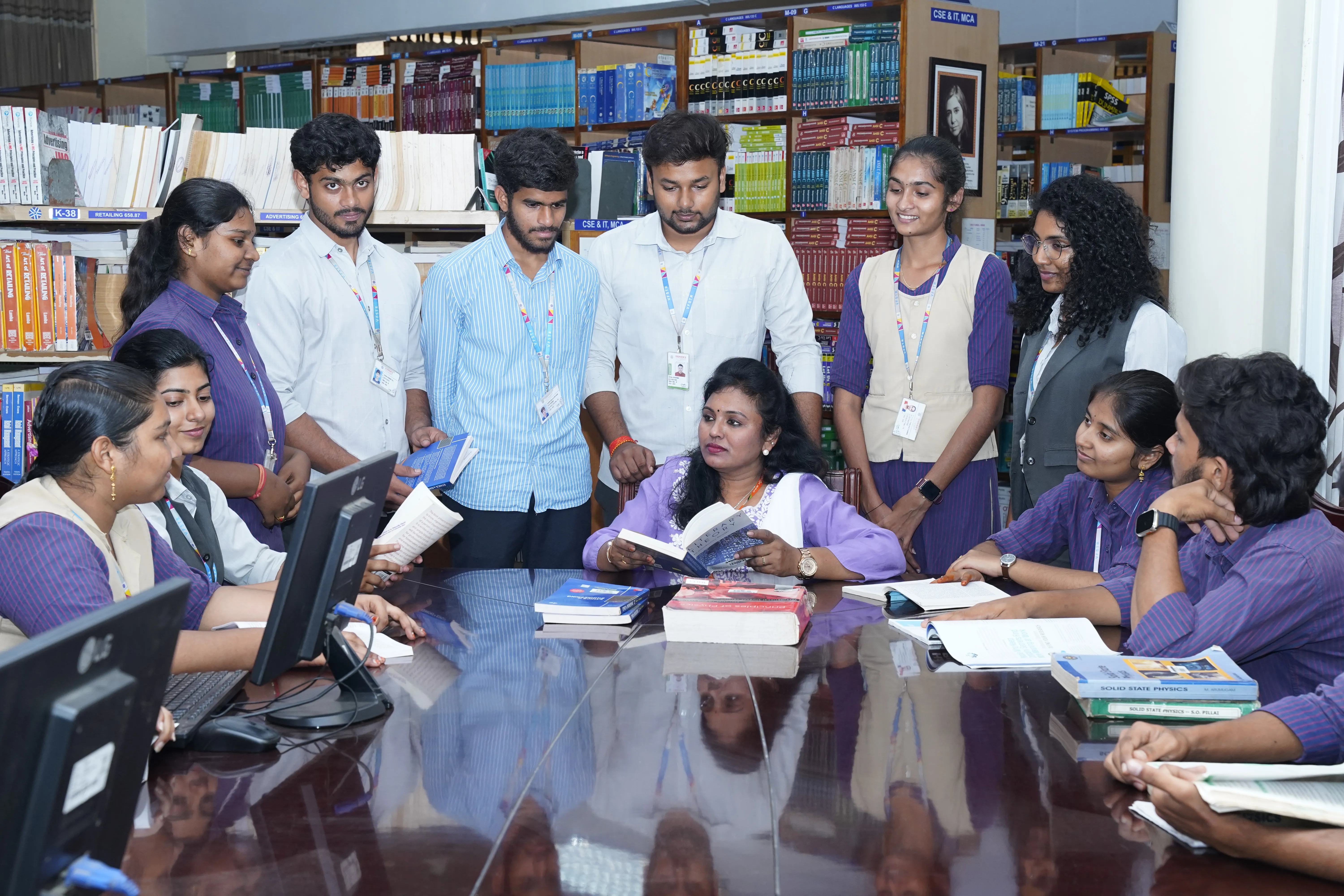 Students and faculty gathered around books in the department library
